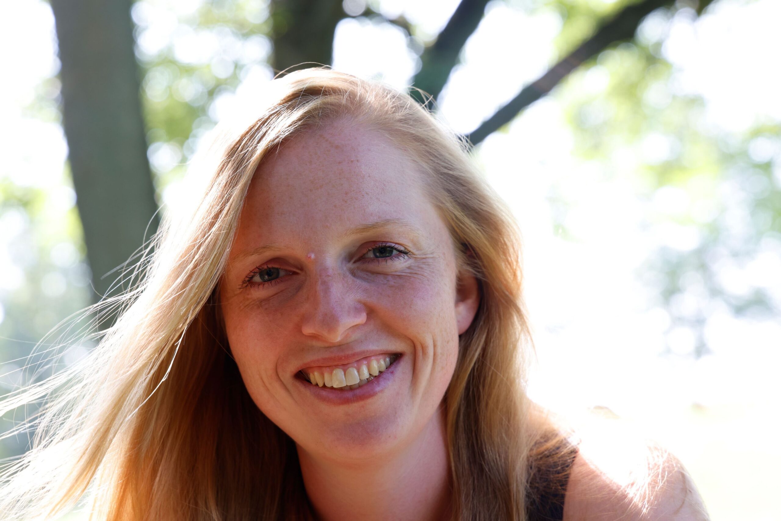 Coach mit landwirtschaftlichem Hintergrund tankt unter Bäumen und im Sonnenschein Kraft